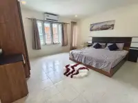 2 Bedroom Townhouse for Rent in East Pattaya bright bedroom with king bed, air conditioner, and wall art