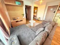 2 Bedroom Condo for Sale at Treetops Condo living room with TV console, wooden shelving and hallway view