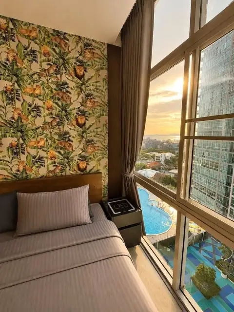 1 Bedroom Condo for Sale at The Twin Tower Jomtien Beach Pattaya bedroom with jungle print wall and pool sunset view