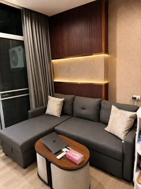 1 Bedroom Condo for Sale at The Twin Tower Jomtien Beach Pattaya sectional sofa with wood accent wall and coffee table