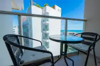 Studio Condo for Sale at Sands Condominium private balcony with rattan chairs and partial sea view through glass railing