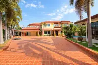5 Bedroom House for Sale in Nong Prue, grand exterior with tiled driveway, palm trees, and blue sky.