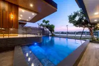 8 Bedroom House for Sale in Nong Prue, swimming pool with blue lighting and steps, surrounded by trees at sunset.