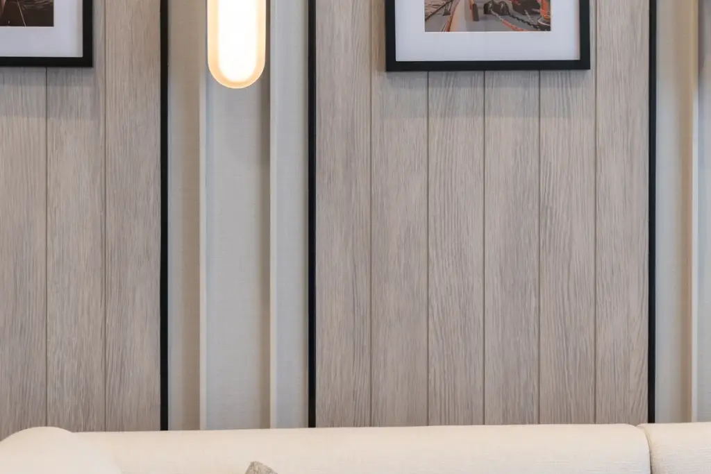 1 Bedroom Condo for Sale at Aquarous Jomtien Pattaya wood-panelled feature wall with oval wall sconce and framed artwork above cream sofa