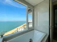 2 Bedroom Condo for Sale at Reflection Jomtien Beach bathtub with floor-to-ceiling window overlooking beach and sea