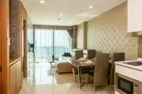 1 Bedroom Condo for Sale at Riviera Wong Amat Beach open-plan living and dining area with gold patterned wallpaper and sea view
