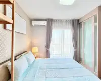 2 Bedroom Condo for Rent at Unicca bedroom with light blue bedding, bedside lamp and balcony window