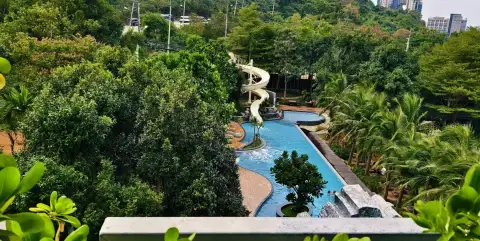 1 Bedroom Condo for Rent at Unixx South Pattaya aerial view of resort pool with waterslide and lush gardens