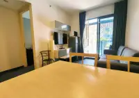 1 Bedroom Condo for Rent at Unixx South Pattaya open-plan living space with wall-mounted TV and balcony access