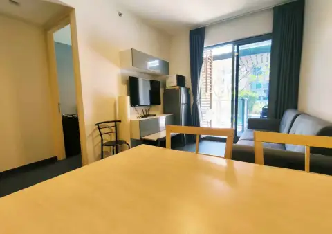 1 Bedroom Condo for Rent at Unixx South Pattaya open-plan living space with wall-mounted TV and balcony access
