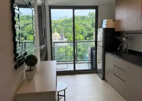 2 Bedroom Condo for Rent at Unixx South Pattaya kitchen with stainless steel fridge and balcony view of temple and trees