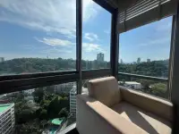 2 Bedroom Condo for Rent at Unixx South Pattaya corner window seating nook with panoramic treetop and skyline view