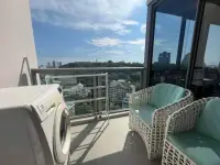 2 Bedroom Condo for Rent at Unixx South Pattaya balcony with rattan chairs, washing machine and city skyline view
