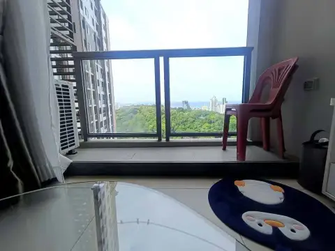 2 Bedroom Condo for Rent at Unixx South Pattaya balcony with chair overlooking treetops and ocean view