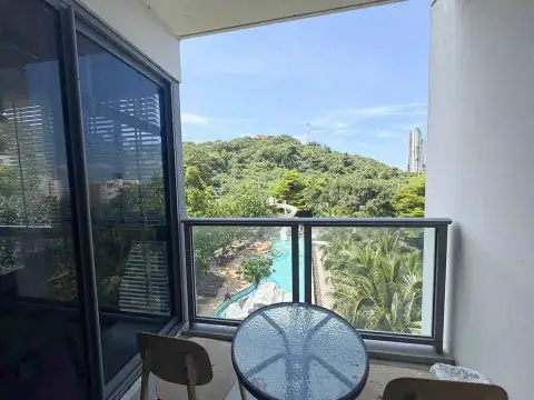 2 Bedroom Condo for Rent at Unixx South Pattaya private balcony with seating area overlooking pool and green hillside