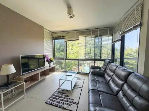 2 Bedroom Condo for Rent at Unixx South Pattaya living area with TV console, coffee table and large windows with pool view