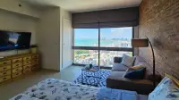 Studio Condo for Rent at Unixx South Pattaya bed and sofa with wall-mounted TV and sea view window