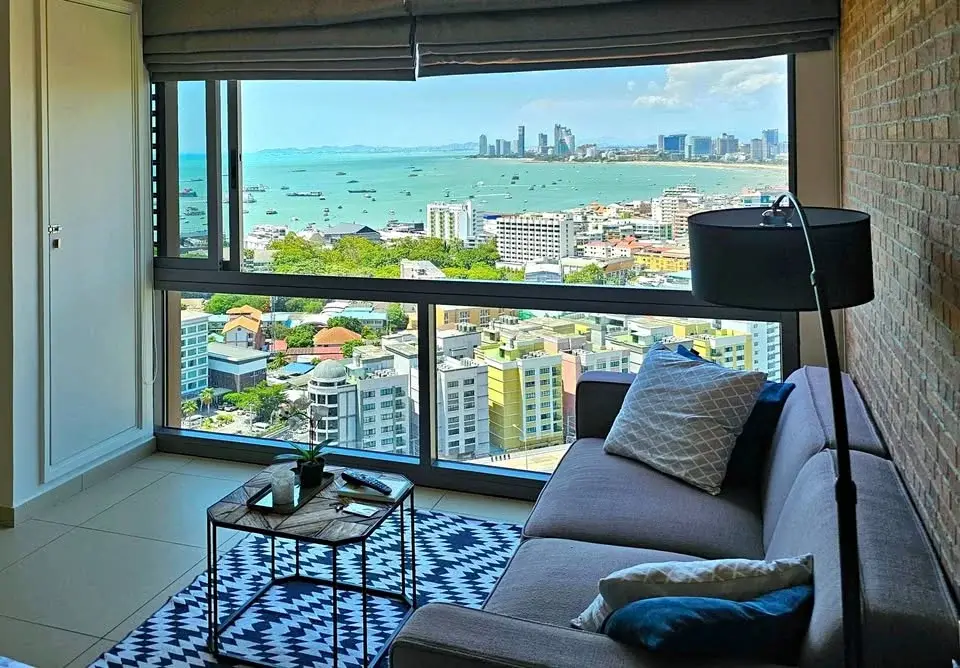 Studio Condo for Rent at Unixx South Pattaya living area with sofa and panoramic sea and city view