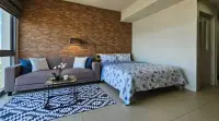 Studio Condo for Rent at Unixx South Pattaya bedroom and lounge with brick accent wall and patterned rug