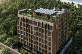 Level Pratumnak condo building exterior aerial view showing gold facade, rooftop garden and beachside palm tree surroundings