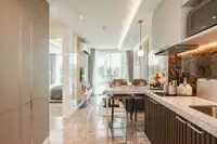 1 Bedroom Condo for Sale at The Coral Pattaya bedroom with large bed, vanity desk, and floor-to-ceiling window to garden.