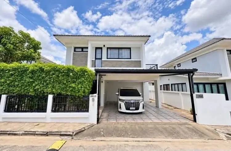 4 Bedroom House for Rent in East Pattaya two-story exterior with carport and white sedan parked