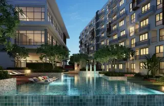 Stasia Dormy Residence evening view of courtyard pool with loungers and illuminated condo buildings