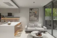 1 Bedroom Condo for Sale at Celine Wongamat open-plan living area with grey sofa, kitchen island, bar stools and balcony garden view