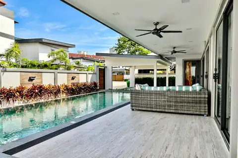 4 Bedroom House for Sale & Rent in Bang Lamung covered poolside terrace with rattan sofa and ceiling fans overlooking private pool