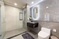 2 Bedroom Condo for Sale at Aquarous Jomtien Pattaya elegant bathroom with glass-enclosed shower, floating vanity, and LED mirror