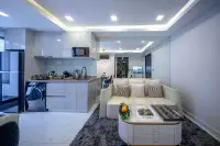 1 Bedroom Condo for Sale at Grand Solaire Noble open-plan living room and white gloss kitchen with sofa and washing machine