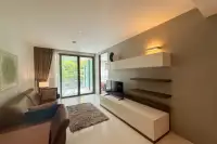 2 Bedroom Condo for Sale & Rent at The Sanctuary Wongamat living room with modern TV wall unit and sliding door balcony