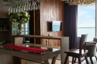 1 Bedroom Condo for Sale at Cetus Beachfront stylish dining space with glass-top table, overhead wine rack, and ocean view window