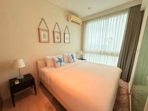 1 Bedroom Condo for Rent at Veranda Residence Pattaya bedroom with white bed, nightstand lamp and sheer curtains