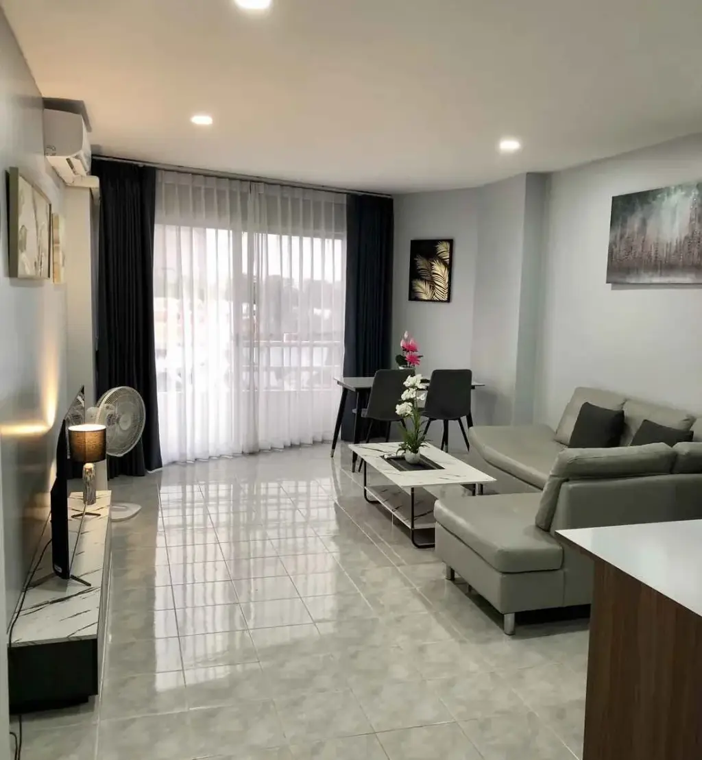1 Bedroom Condo for Rent at View Talay 1 living room with gray sofa, dining table, and balcony views