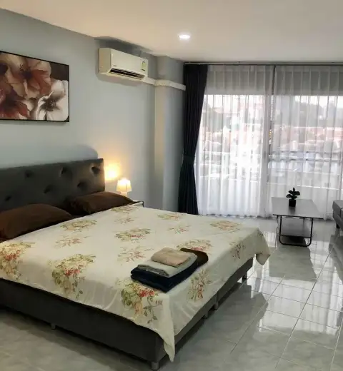 1 Bedroom Condo for Rent at View Talay 1 bedroom with floral bedspread and sheer curtained balcony