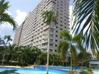 View Talay 2 large outdoor swimming pool with blue tiles, shaded seating, and surrounding tropical greenery.