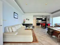 2 Bedroom Condo for Sale at View Talay 3A open-plan living room with white sofa and kitchen bar area