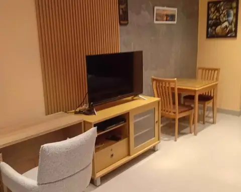 Studio Condo for Rent at View Talay 5D dining area with wooden table, chairs, TV stand, and flat-screen television
