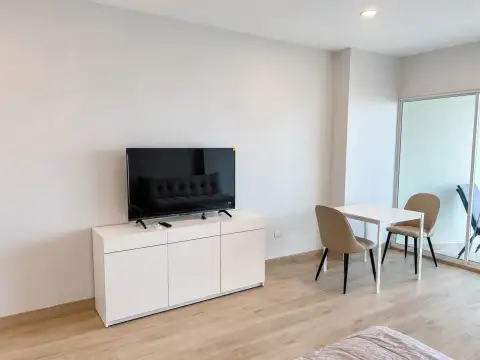 Studio Condo for Rent at View Talay 5D living area with flat-screen TV, dining table and balcony access