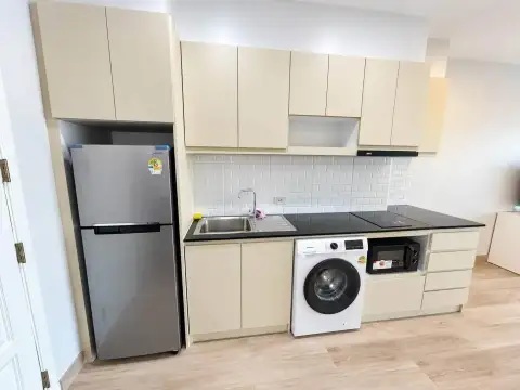 Studio Condo for Rent at View Talay 5D kitchen with refrigerator, washing machine and black countertop
