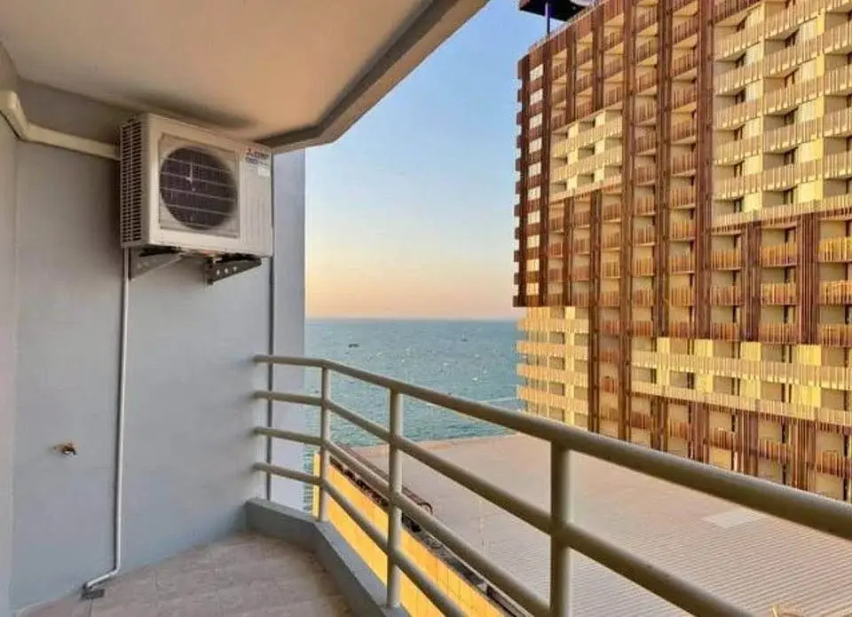 Studio Condo for Sale at View Talay 6 balcony with sea view and neighboring high-rise building at sunset