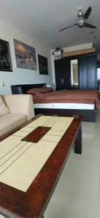 1 Bedroom Condo for Sale at View Talay 6 living area with sofa, coffee table, and bed with wall art