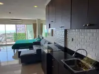 1 Bedroom Condo for Sale at View Talay 7 kitchenette with black countertop and ocean-view balcony beyond