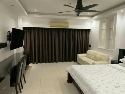 Studio Condo for Rent at View Talay 8 bedroom with king bed, wall-mounted TV, cream sofa and blackout curtains