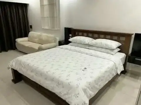 Studio Condo for Rent at View Talay 8 cozy bedroom with floral bedspread, sofa and nightstand