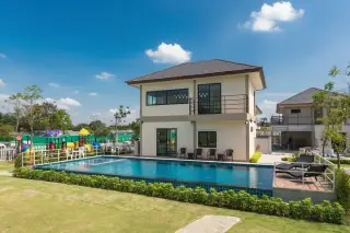 Villa Asiatic two-story house with a large swimming pool, sun loungers, and a nearby children's playground.