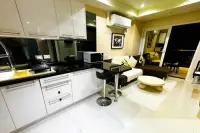 1 Bedroom Condo for Rent at VN Residence 3 open-plan kitchen with white cabinets and living room with sofa