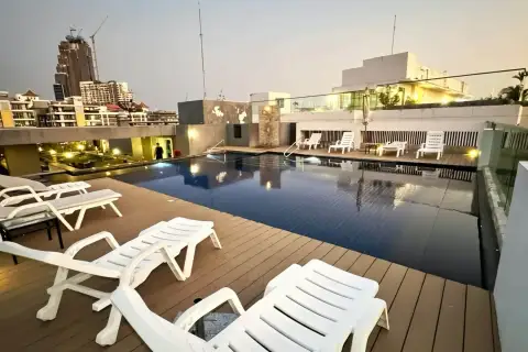 1 Bedroom Condo for Rent at VN Residence 3 rooftop swimming pool with lounge chairs and city skyline at dusk
