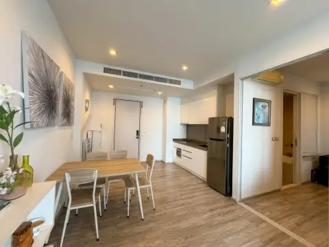 1 Bedroom Condo for Sale at Baan Plai Haad open-plan dining area with kitchenette and wooden table